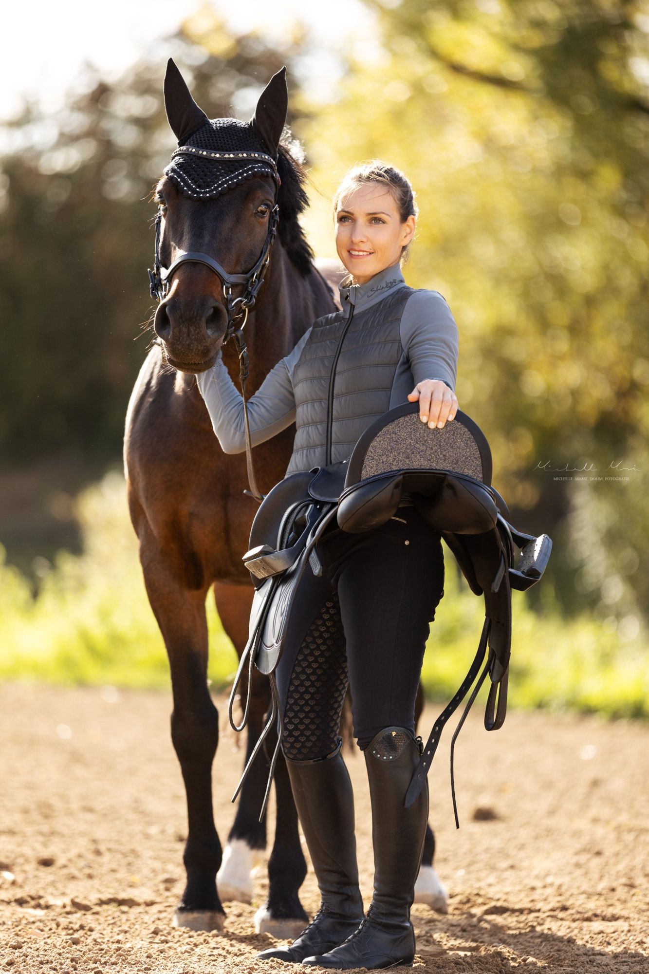 Rider holding an Equiveron saddle with glitter halfmoon next to her horse